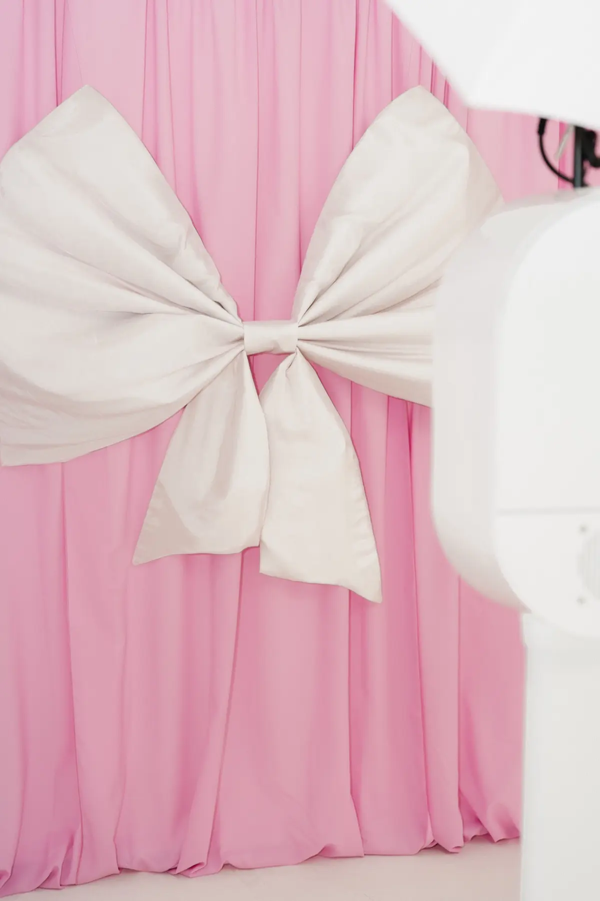 Bridal photo booth with pink bow backdrop in Los Angeles