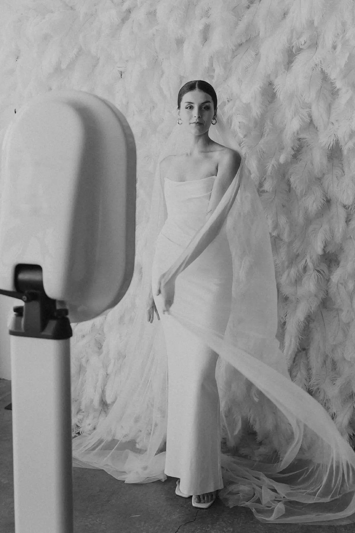 Flower wall feather photo booth rental showing wearable props in action