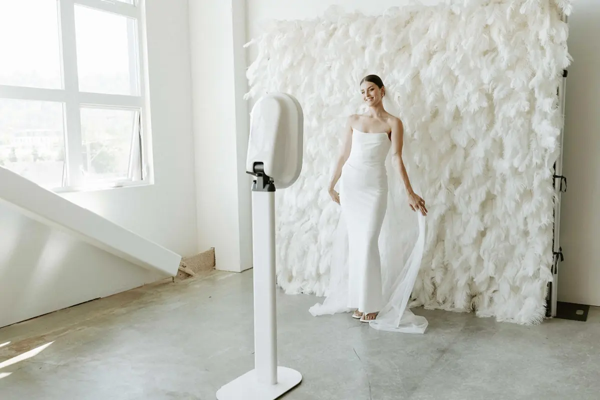 Flower wall feather photo booth rental with organized prop display