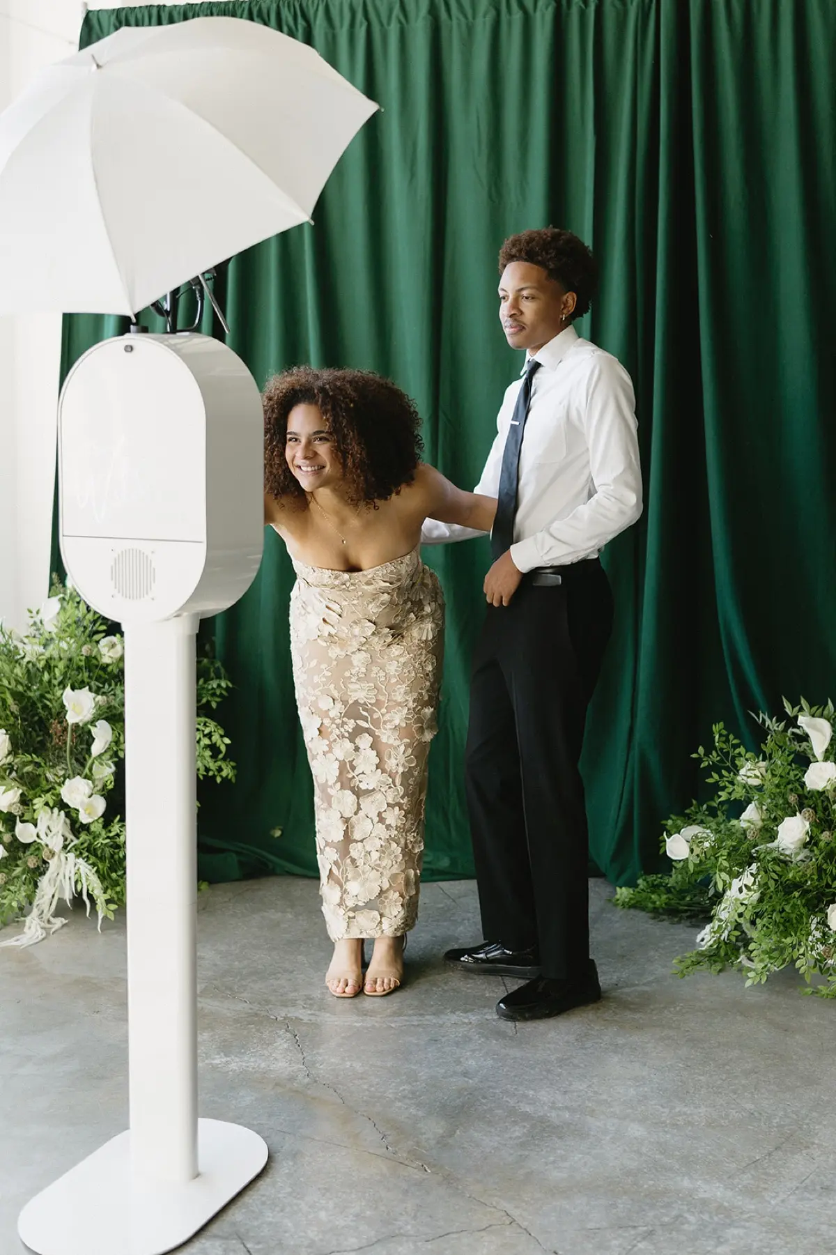 Velour floral photo booth with lush green backdrop creating elegant Los Angeles event ambiance